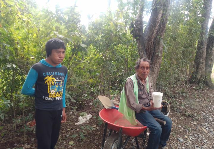 Mariano Asunción, junto a su hijo, bachean la carretera de Tampacán